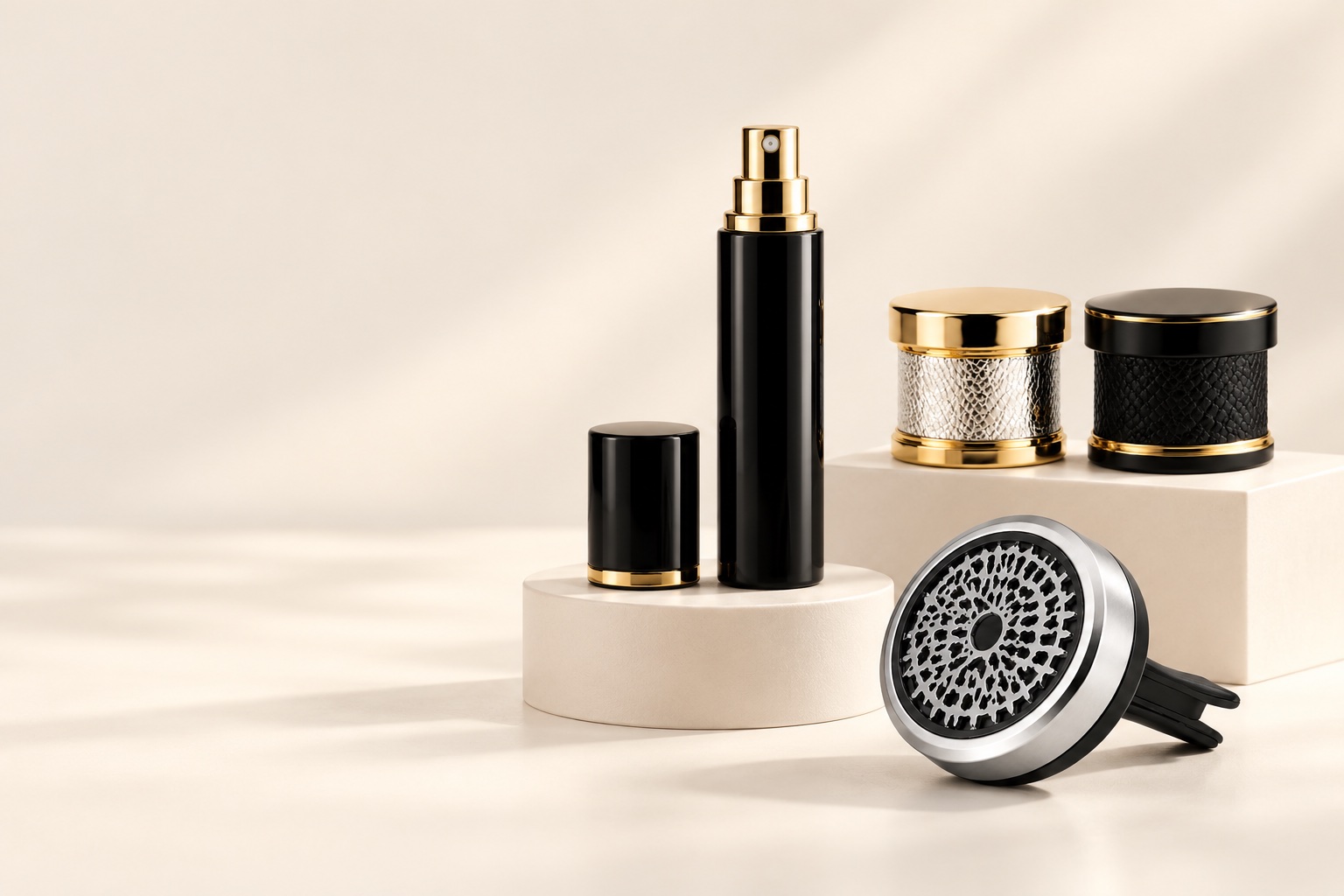 Black perfume atomizer, gold-tone perfume caps and round car fragrance diffuser displayed together