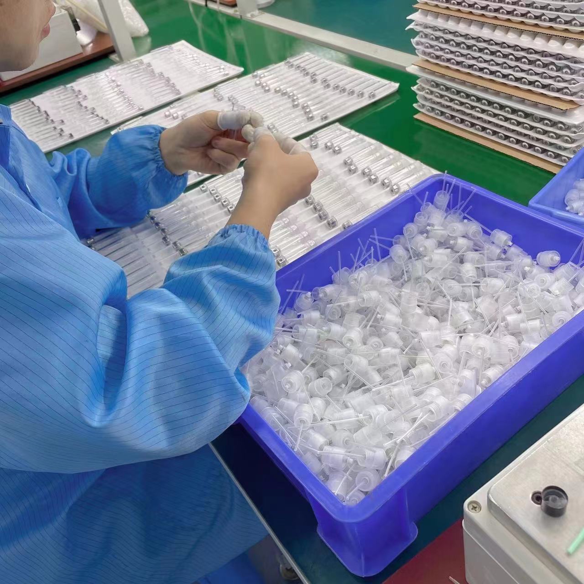 Operator fitting spray pump components at a production workbench